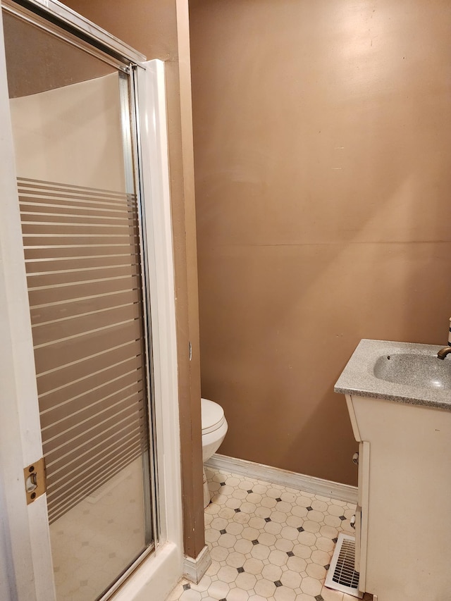 bathroom featuring vanity, an enclosed shower, and toilet