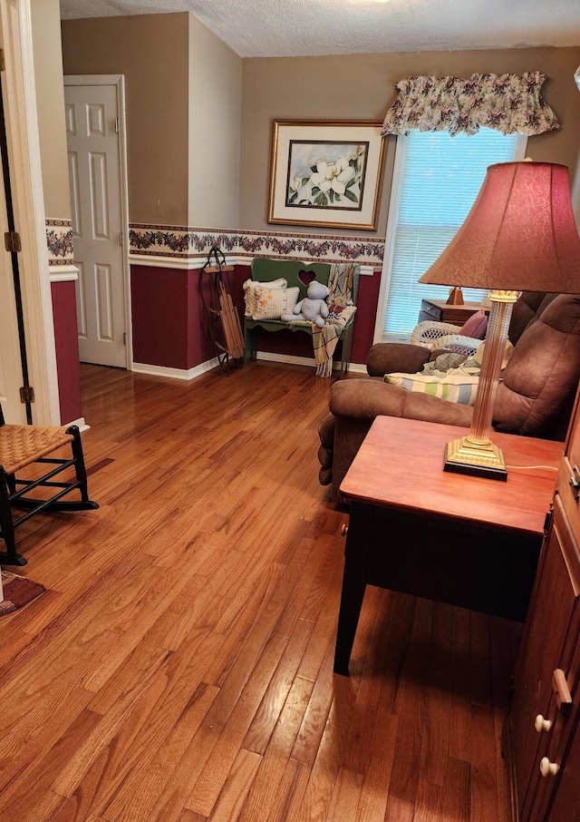 living area featuring a textured ceiling and light hardwood / wood-style floors