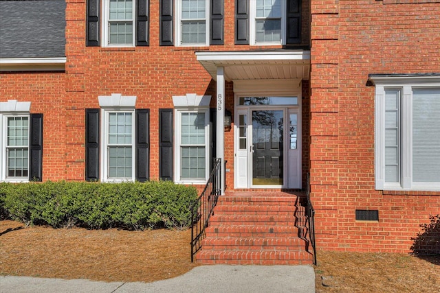 doorway to property with crawl space and brick siding