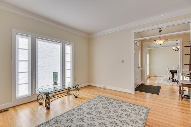 interior space with a wealth of natural light, crown molding, and wood finished floors