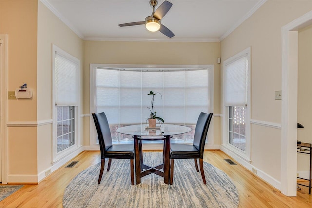 dining room with visible vents, crown molding, and wood finished floors