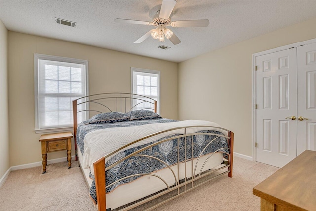 bedroom with baseboards, carpet, visible vents, and a textured ceiling