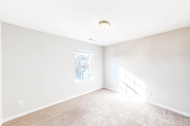 unfurnished room featuring light carpet