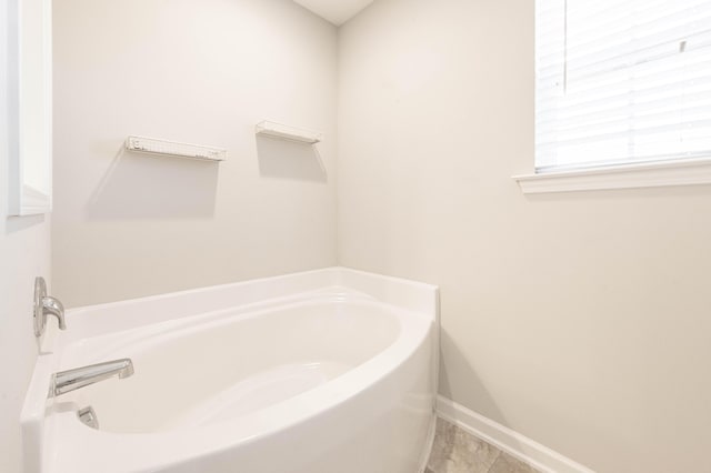 bathroom featuring tile patterned flooring and a tub to relax in