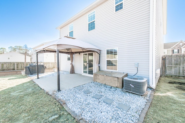 back of property featuring central AC unit, a patio area, a gazebo, and a yard