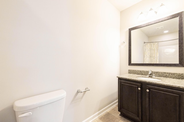 bathroom featuring toilet, tile patterned flooring, walk in shower, and vanity