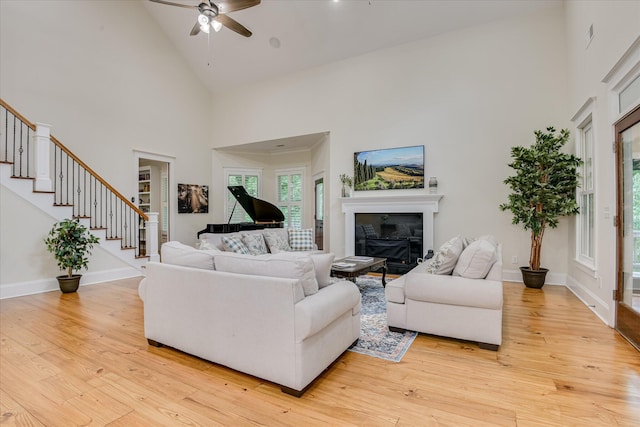 1020 Peninsula Xing, Evans, GA 30809 - living area featuring high vaulted ceiling, a ceiling fan, light wood-type flooring, stairway, and a glass covered fireplace
