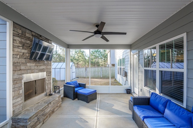 sunroom / solarium with ceiling fan and an outdoor stone fireplace