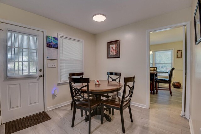 kitchen featuring tasteful backsplash, white cabinetry, light hardwood / wood-style flooring, and stainless steel appliances