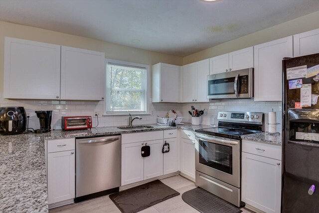 kitchen with stainless steel appliances, kitchen peninsula, a breakfast bar, white cabinets, and light wood-type flooring