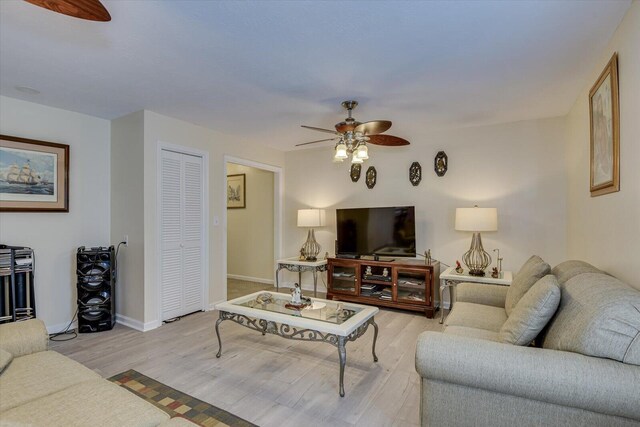 living room with ceiling fan and light hardwood / wood-style flooring