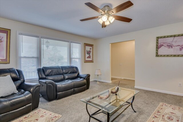 carpeted living room with ceiling fan with notable chandelier and plenty of natural light