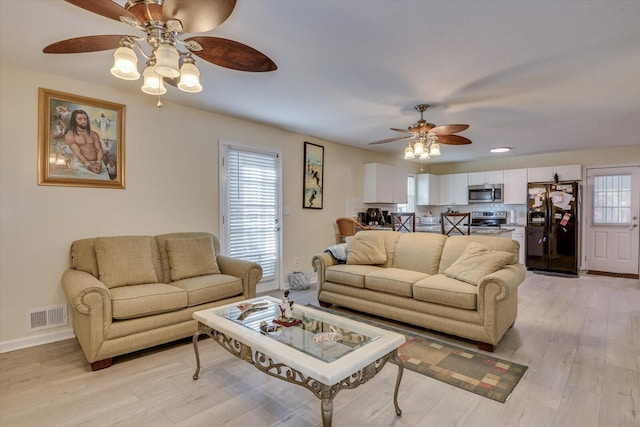 living room with ceiling fan and light wood-type flooring