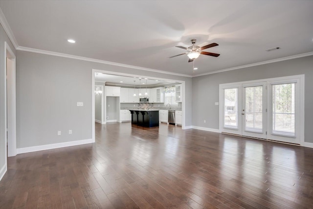 unfurnished living room featuring ceiling fan, dark hardwood / wood-style floors, ornamental molding, and sink