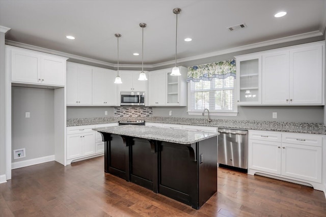 kitchen with a center island, sink, light stone counters, white cabinetry, and stainless steel appliances