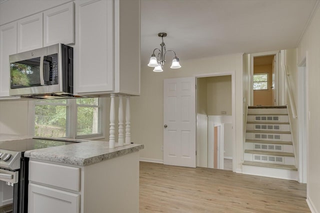 kitchen featuring a notable chandelier, light wood finished floors, hanging light fixtures, appliances with stainless steel finishes, and white cabinets