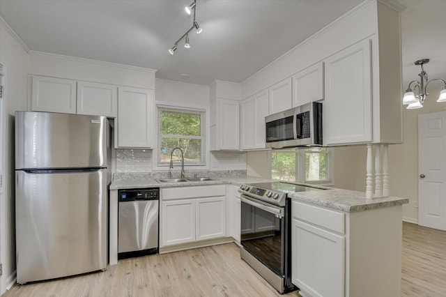 kitchen with crown molding, stainless steel appliances, light wood-style flooring, white cabinets, and a sink