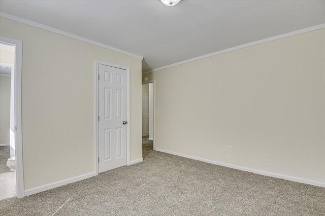 unfurnished bedroom featuring carpet, baseboards, and crown molding