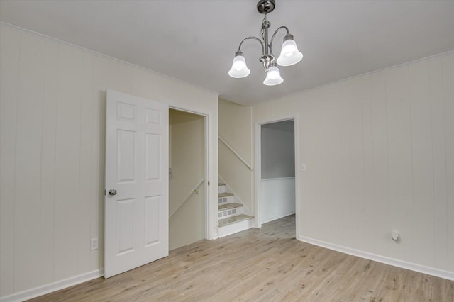 unfurnished room featuring baseboards, stairway, light wood-type flooring, and an inviting chandelier