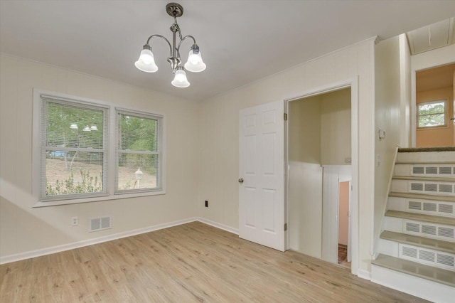 unfurnished dining area featuring visible vents, stairway, light wood-style flooring, and an inviting chandelier