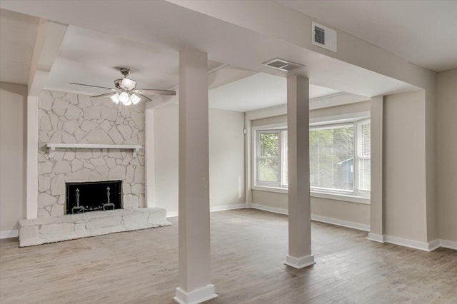 unfurnished living room featuring visible vents, a fireplace, baseboards, and wood finished floors