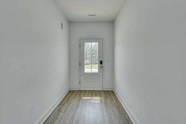 entryway featuring visible vents, baseboards, and wood finished floors