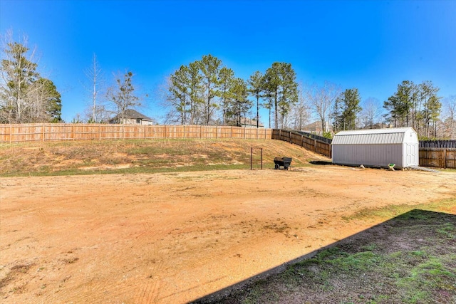 view of yard featuring an outbuilding, a fenced backyard, and a shed