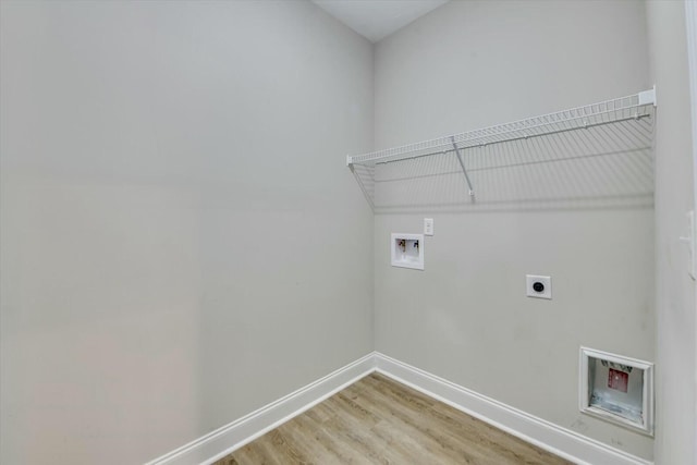 washroom with electric dryer hookup, light wood-type flooring, washer hookup, baseboards, and laundry area