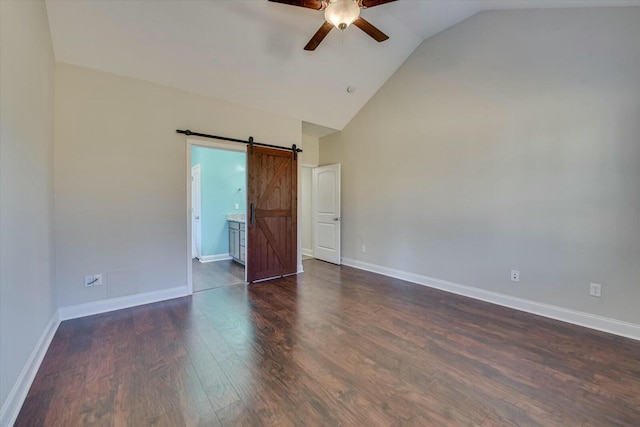 unfurnished bedroom featuring a barn door, baseboards, high vaulted ceiling, and dark wood-style floors