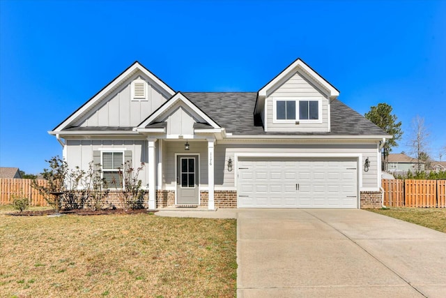 view of front of home with driveway, fence, board and batten siding, a front yard, and brick siding