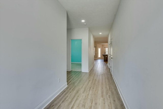 corridor with recessed lighting, light wood-style floors, and baseboards