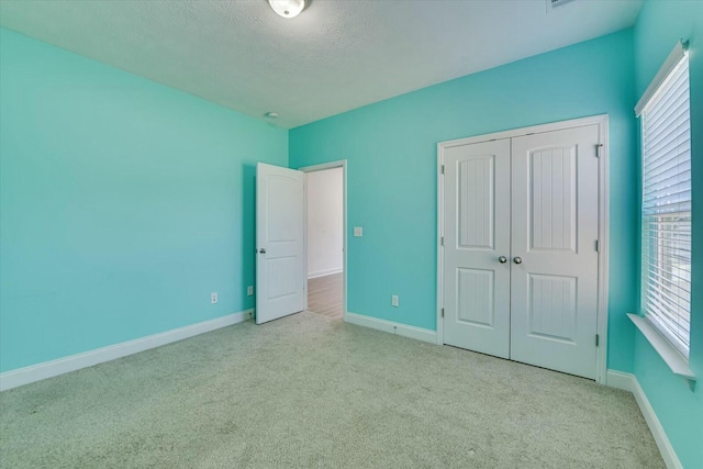 unfurnished bedroom featuring a closet, multiple windows, and carpet floors