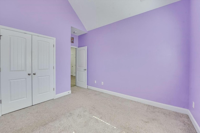 unfurnished bedroom with a closet, carpet flooring, high vaulted ceiling, and baseboards