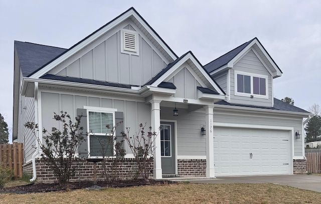 view of front of house with brick siding, an attached garage, board and batten siding, fence, and driveway