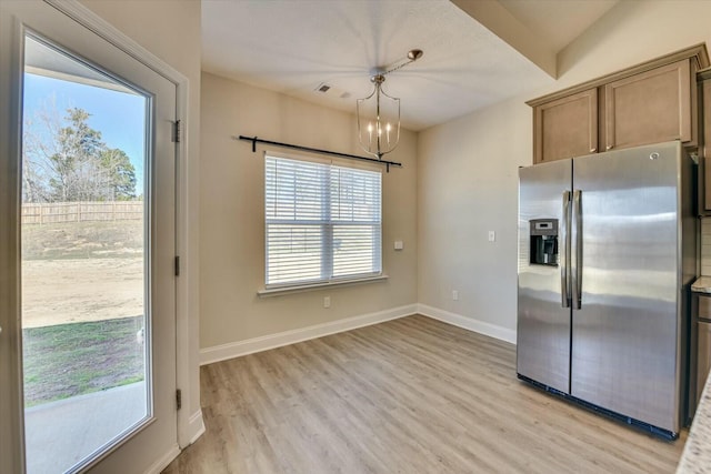 kitchen featuring light wood-style floors, visible vents, stainless steel fridge, and baseboards