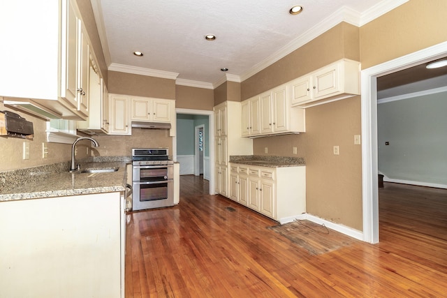 2531 Tupelo Dr, Augusta, GA 30909 - kitchen featuring range with two ovens, crown molding, wood-type flooring, light stone countertops, and under cabinet range hood