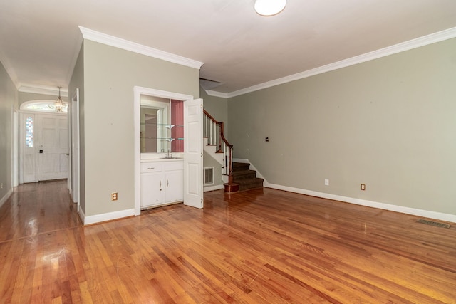 2531 Tupelo Dr, Augusta, GA 30909 - empty room featuring stairs, light wood-style floors, crown molding, and a chandelier