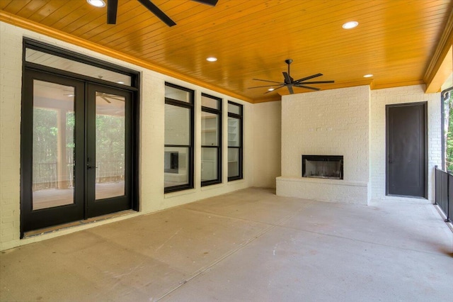 view of patio featuring ceiling fan, a fireplace, and french doors