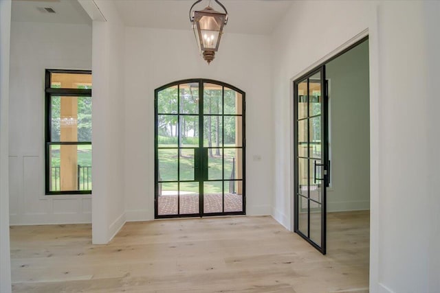 entryway with french doors and light hardwood / wood-style floors