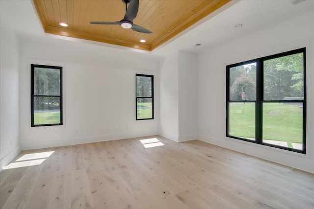 empty room featuring ceiling fan, light hardwood / wood-style floors, wooden ceiling, and a tray ceiling