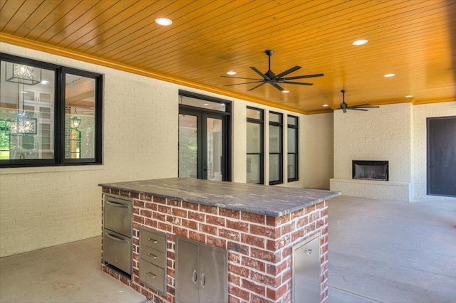 view of patio featuring ceiling fan, a fireplace, and an outdoor bar