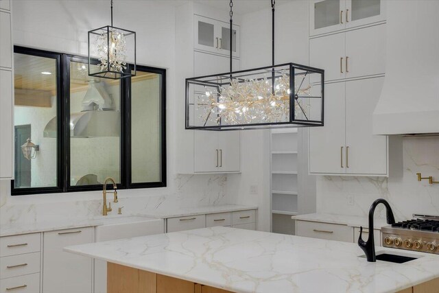 bathroom featuring backsplash, a notable chandelier, and sink