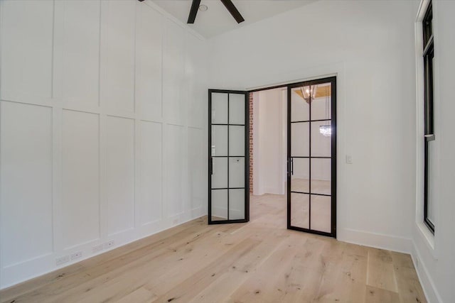 unfurnished room with french doors, light hardwood / wood-style floors, and ceiling fan