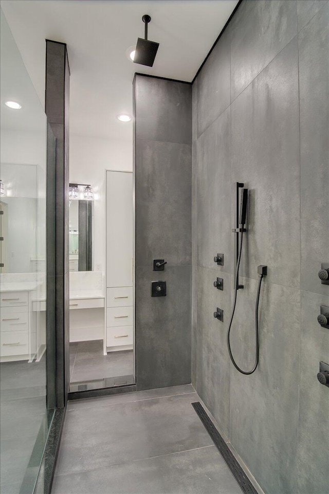 bathroom featuring vanity, a shower, and concrete flooring