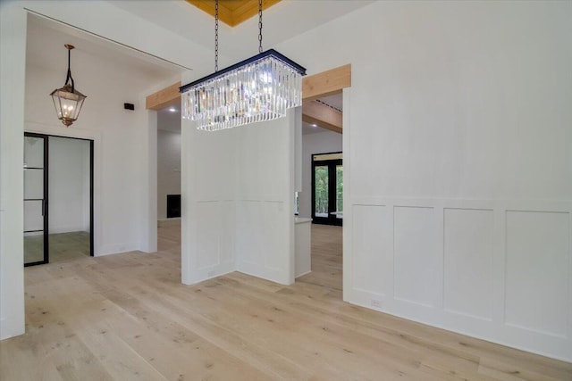 unfurnished dining area with light wood-type flooring and an inviting chandelier