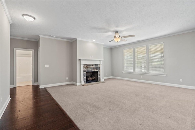 unfurnished living room with ceiling fan, crown molding, a textured ceiling, a fireplace, and carpet