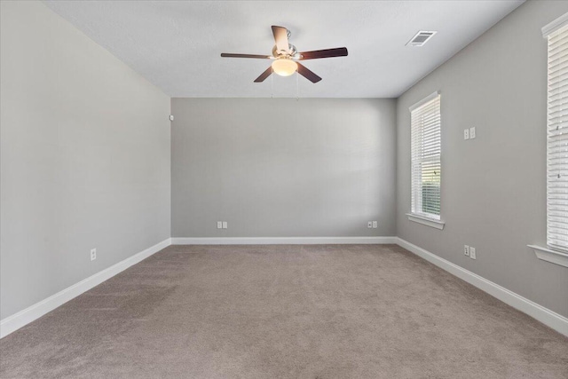 empty room featuring ceiling fan and light colored carpet