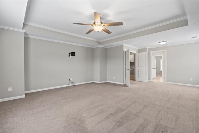 carpeted empty room featuring ceiling fan, ornamental molding, and a tray ceiling