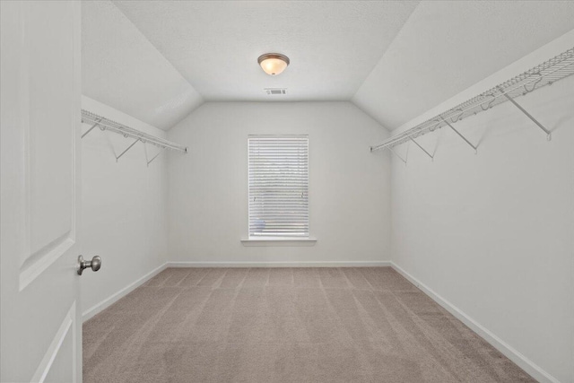 walk in closet with carpet flooring and lofted ceiling