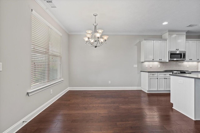 kitchen with decorative backsplash, dark hardwood / wood-style flooring, a notable chandelier, white cabinets, and hanging light fixtures